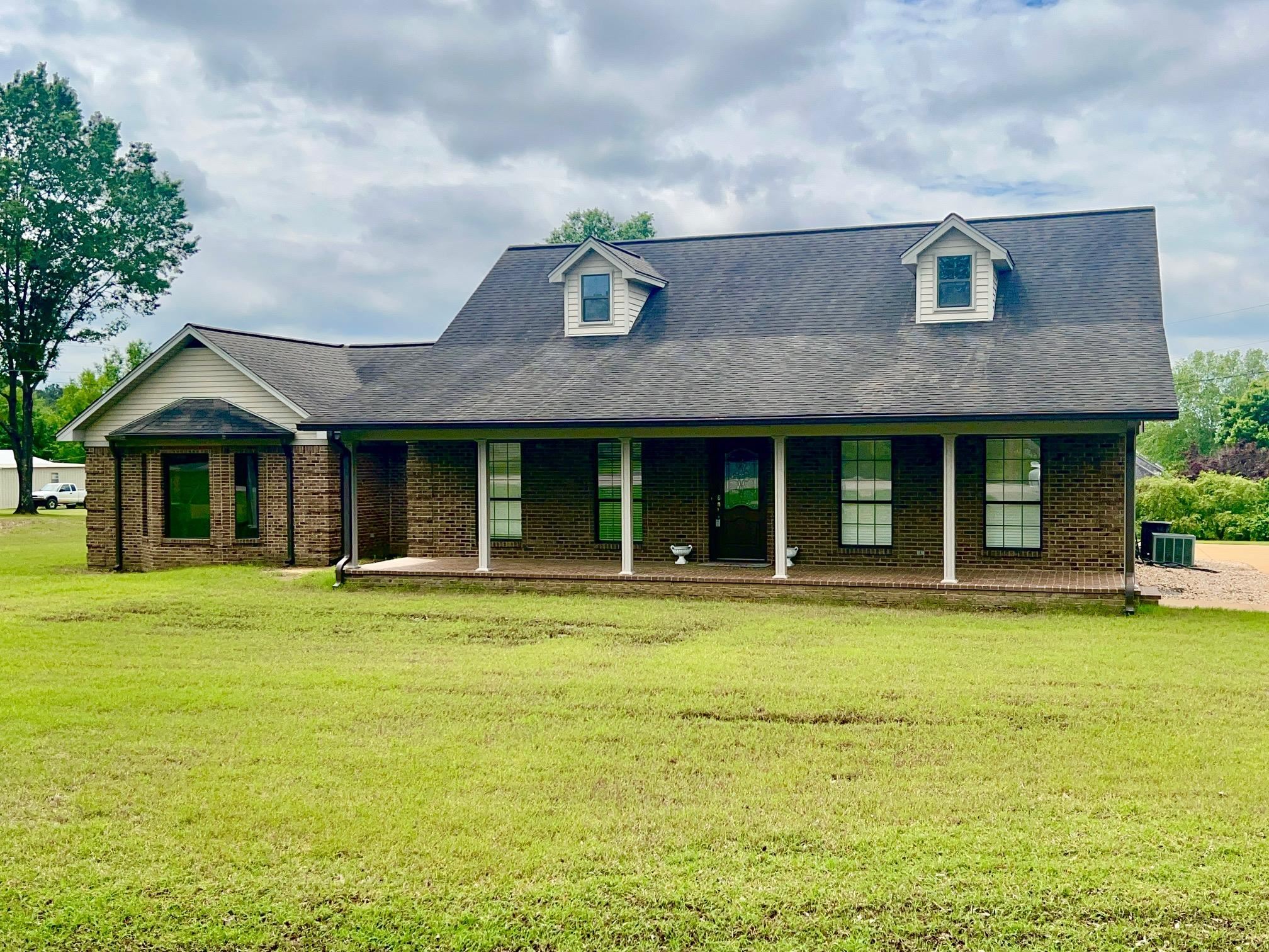 101 Peacock Holler Ripley, MS 38663 - Photo 2 of 25 a front view of a house with a garden and porch