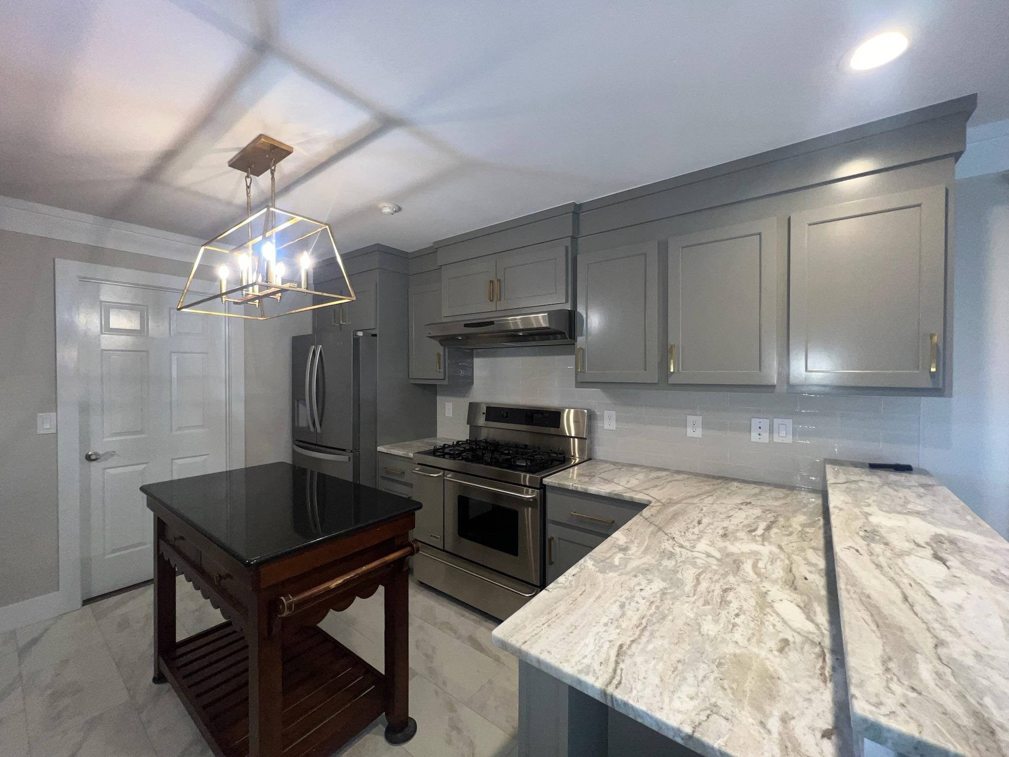 101 Peacock Holler Ripley, MS 38663 - Photo 7 of 25 a kitchen with stainless steel appliances granite countertop a oven a stove and a refrigerator