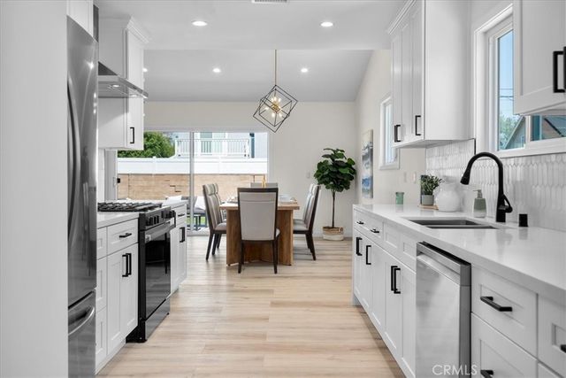 a kitchen with appliances a sink and cabinets