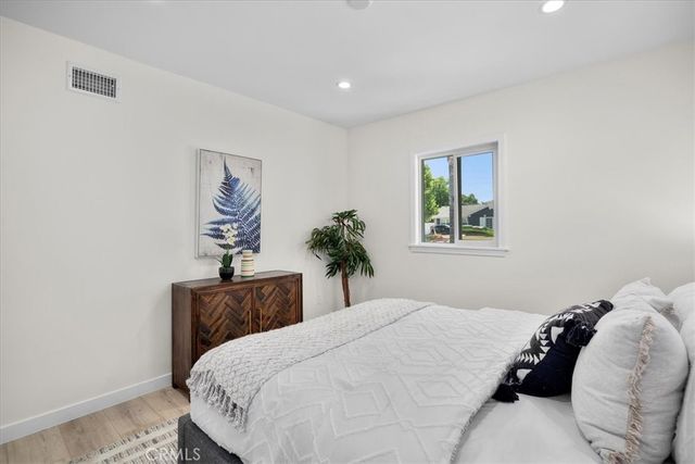 a bedroom with a bed and a painting on the wall
