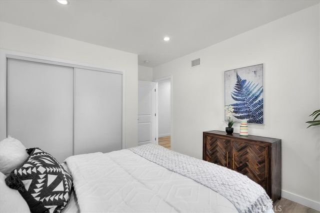 a bedroom with a bed and a painting on the wall