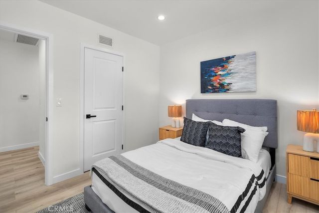 a bedroom with a bed and wooden floor