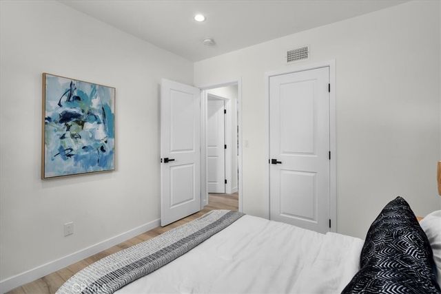 a bedroom with a bed and a painting on the wall