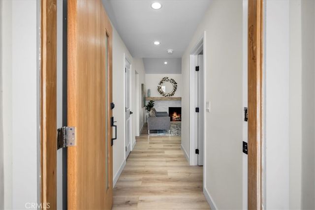 a view of a hallway with wooden floor windows and a livingroom