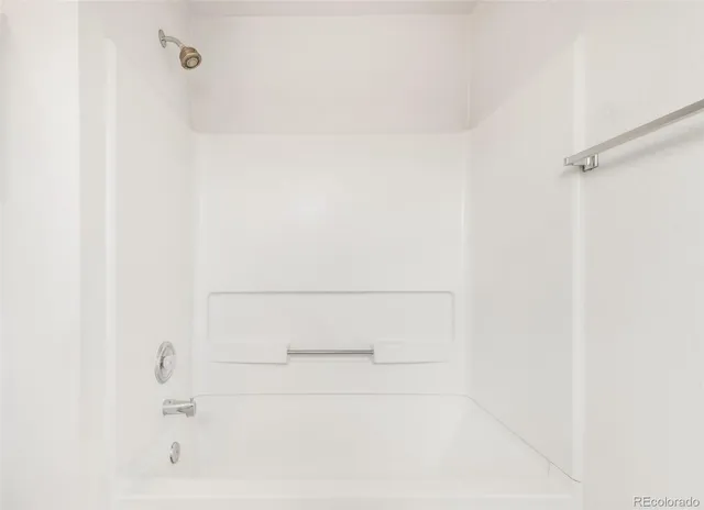 an empty room with a chandelier fan