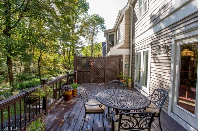 a view of balcony with table and chairs and wooden fence