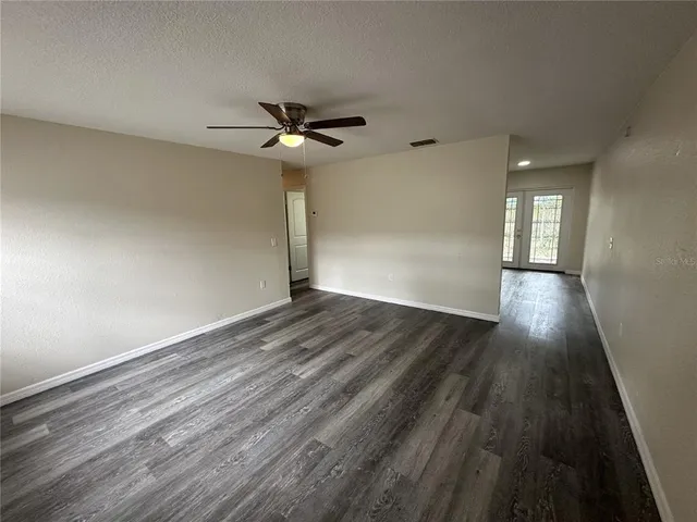a view of empty room with wooden floor