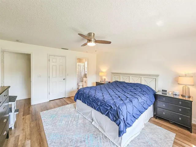 a spacious bedroom with a bed and a dresser