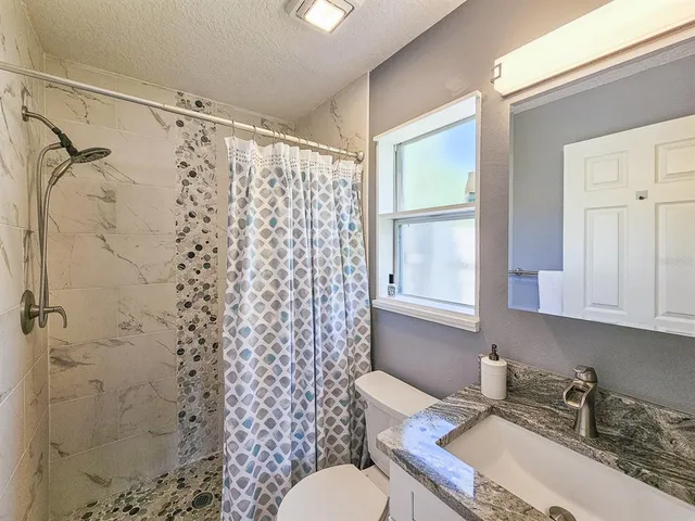 a bathroom with a sink toilet and shower