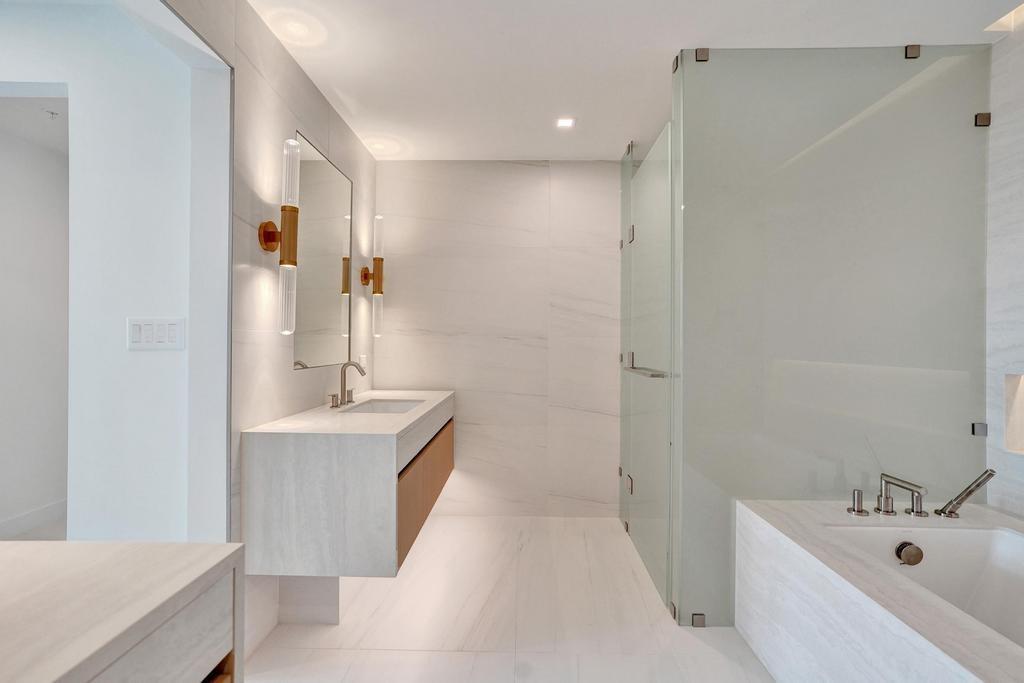 900 North Ocean Boulevard, Unit 302 Pompano Beach, FL 33062 - Photo 27 of 62 a bathroom with a tub sink and mirror