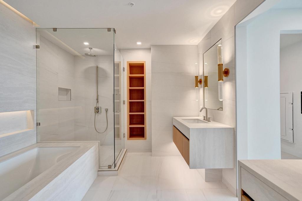 900 North Ocean Boulevard, Unit 302 Pompano Beach, FL 33062 - Photo 28 of 62 a bathroom with a tub a sink and mirrors