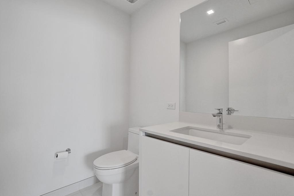 900 North Ocean Boulevard, Unit 302 Pompano Beach, FL 33062 - Photo 32 of 62 a bathroom with a sink toilet and a mirror