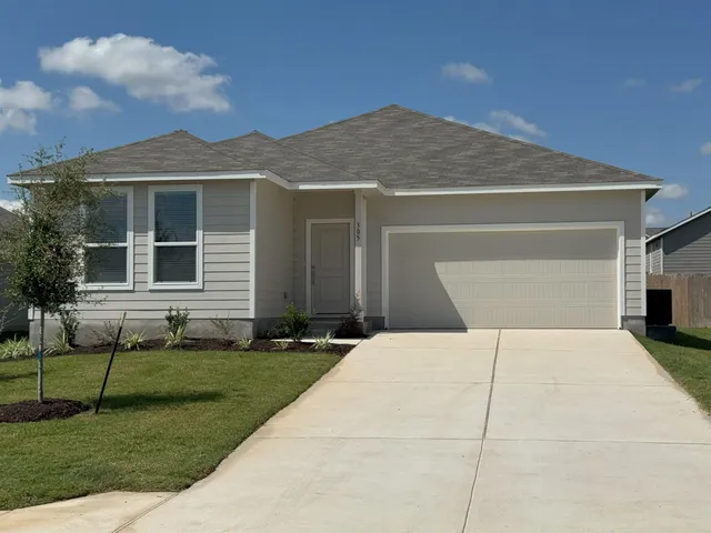 a front view of a house with a yard and garage