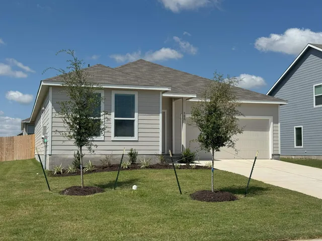 a backyard of a house with table and chairs