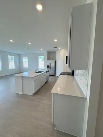 a large white kitchen with a white countertops and a couch