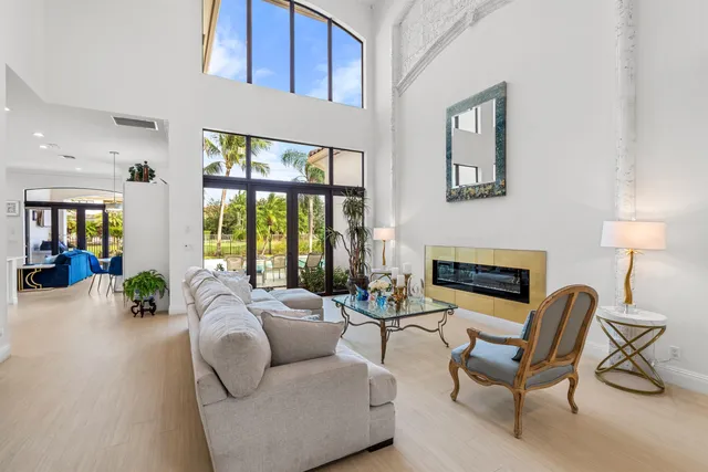 a living room with furniture a fireplace and a floor to ceiling window