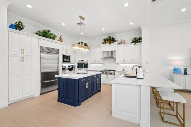 a large kitchen with kitchen island a sink stainless steel appliances and cabinets