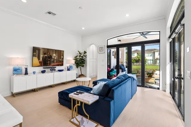 a living room with furniture a flat screen tv and a floor to ceiling window