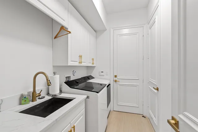 a kitchen with a refrigerator sink and white cabinets