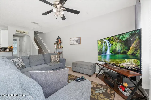 a living room with furniture and a floor to ceiling window