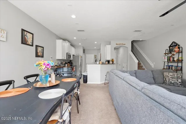 a living room with furniture and kitchen view