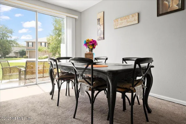a view of a dining room with furniture large windows and wooden floor