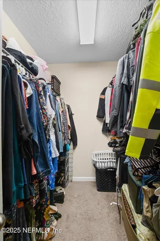 a view of walk in closet with clothes and shoes
