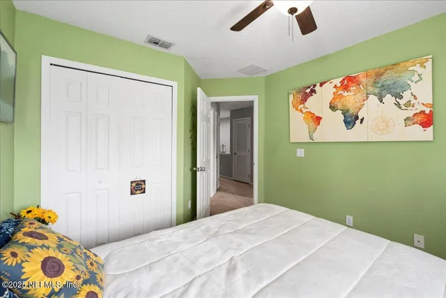 a bedroom with a bed and a painting on the wall