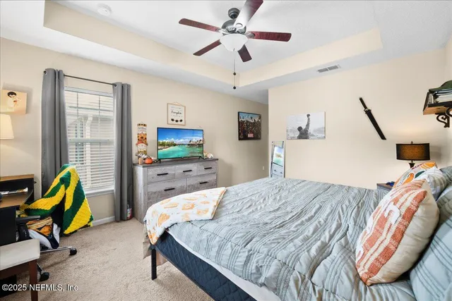 a bedroom with a bed a couch and a chandelier