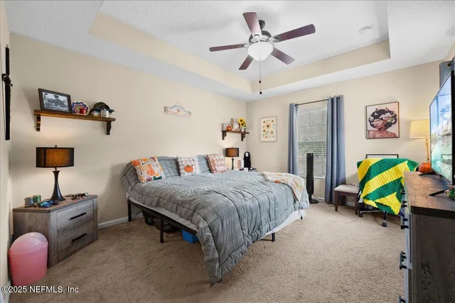 a bedroom with a bed a couch and a chandelier