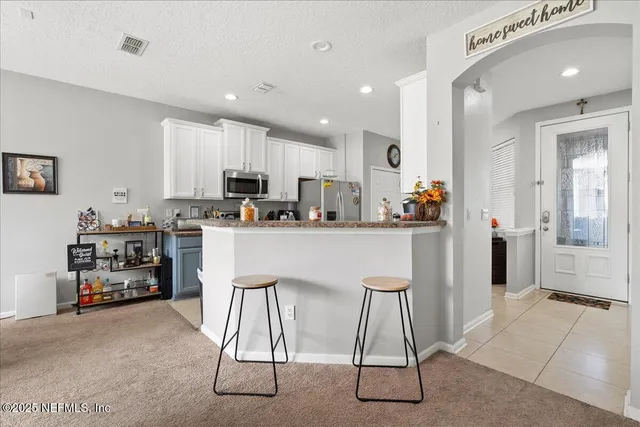 a kitchen with stainless steel appliances kitchen island granite countertop a refrigerator sink and cabinets