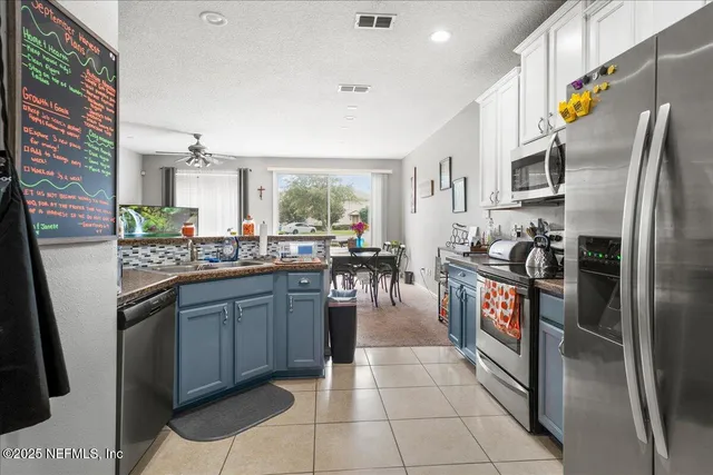 a kitchen with stainless steel appliances granite countertop a refrigerator a stove and a sink