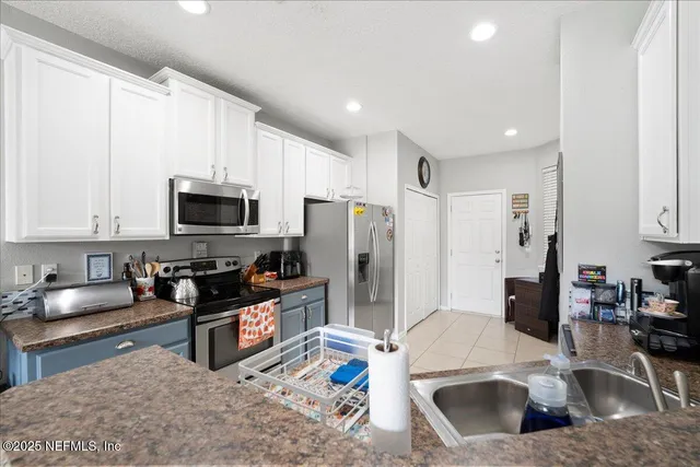 a kitchen with stainless steel appliances a stove a sink a refrigerator a stove a microwave and cabinets