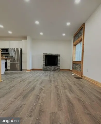 a kitchen with wooden floors and a fireplace