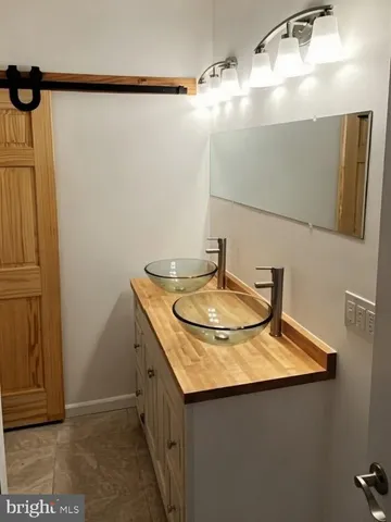a bathroom with a granite countertop sink and mirror