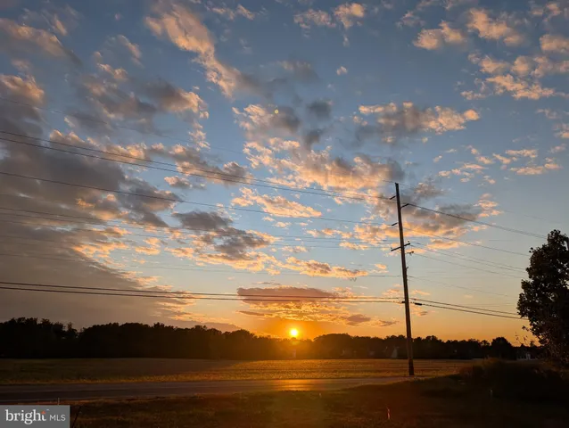 a front view of a house with lots of green space and a fire pit