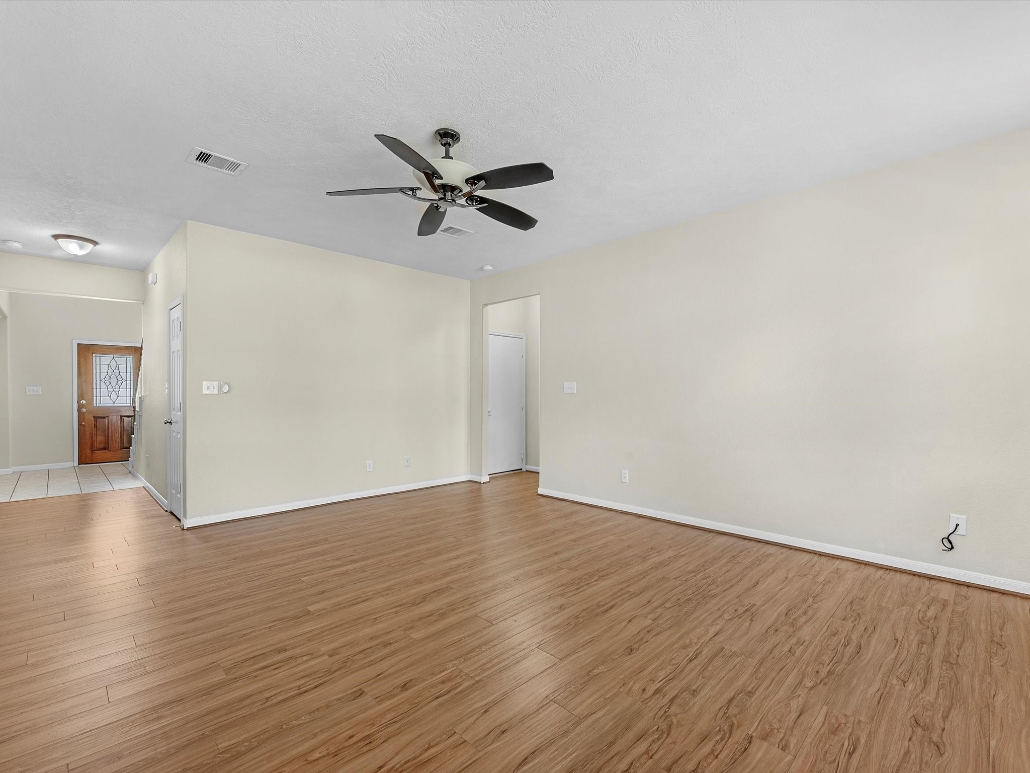 13307 Bomoseen Lake Road Houston, TX 77044 - Photo 11 of 40 a view of an empty room with wooden floor and a ceiling fan