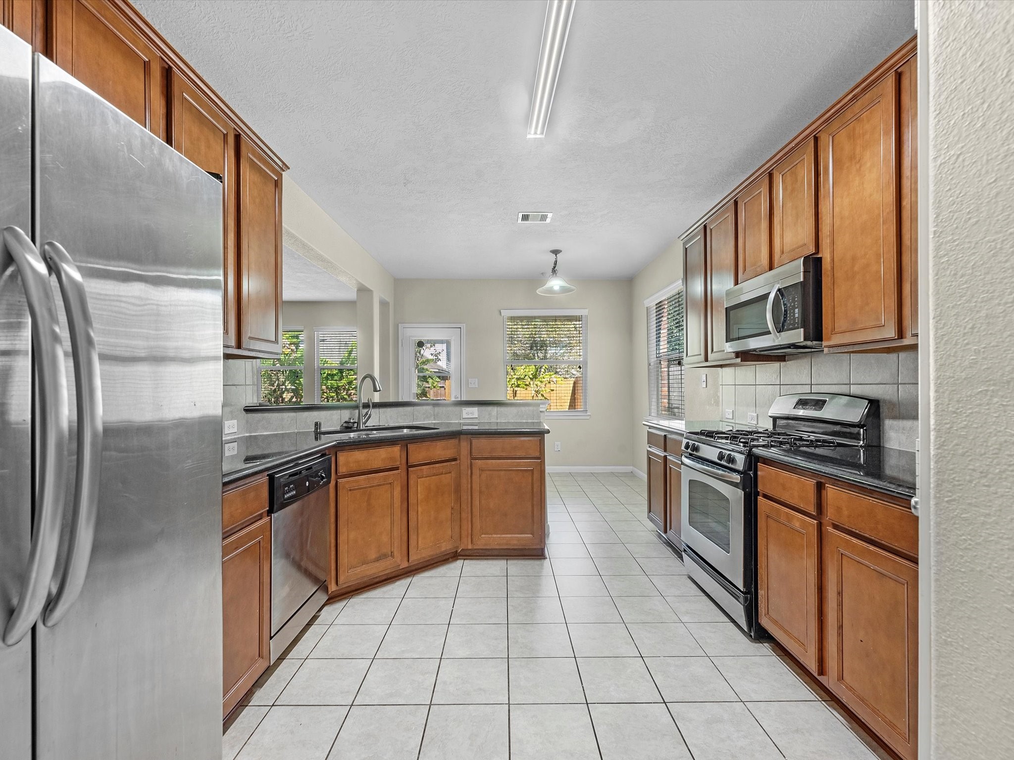 13307 Bomoseen Lake Road Houston, TX 77044 - Photo 13 of 40 a kitchen with stainless steel appliances granite countertop a refrigerator a sink a stove top oven and cabinets