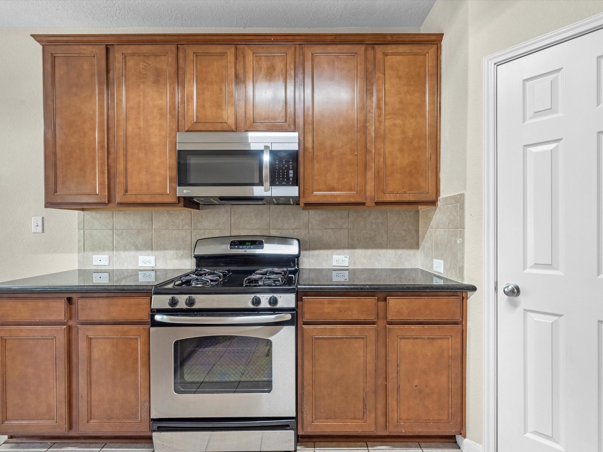 13307 Bomoseen Lake Road Houston, TX 77044 - Photo 15 of 40 a kitchen with granite countertop wooden cabinets and stainless steel appliances