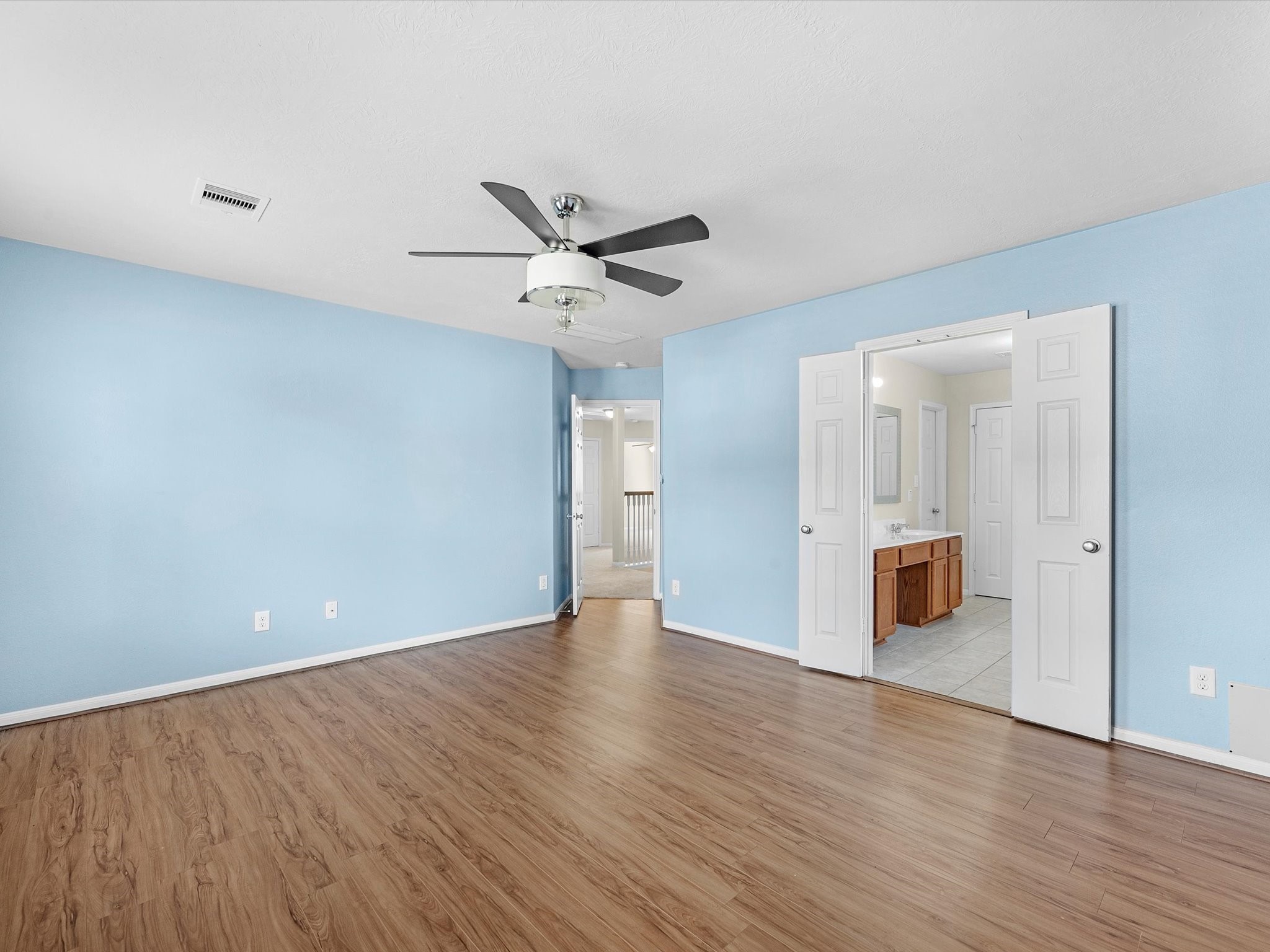 13307 Bomoseen Lake Road Houston, TX 77044 - Photo 25 of 40 a view of an empty room with wooden floor and a ceiling fan