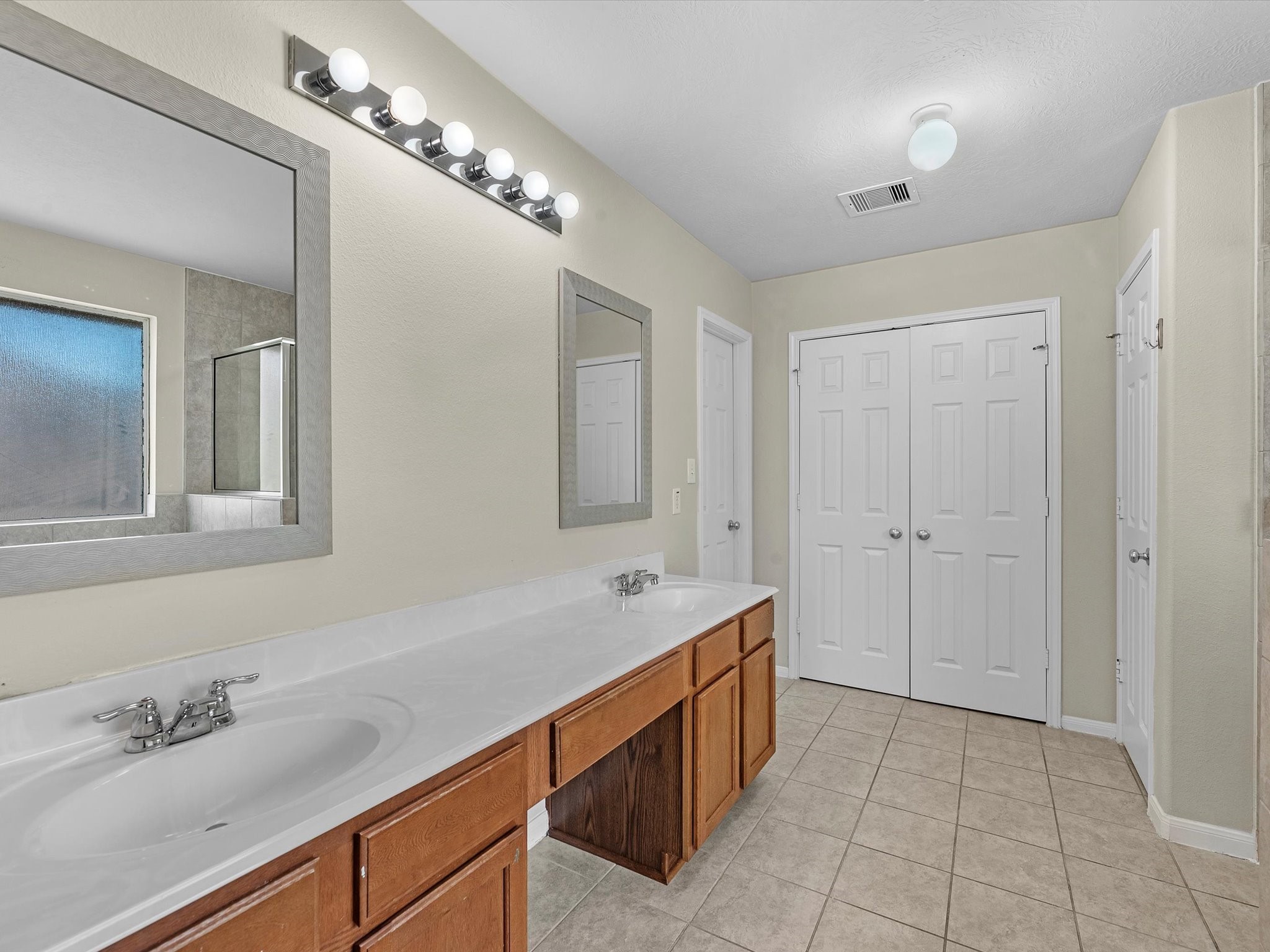 13307 Bomoseen Lake Road Houston, TX 77044 - Photo 26 of 40 a spacious bathroom with a double vanity sink and a mirror
