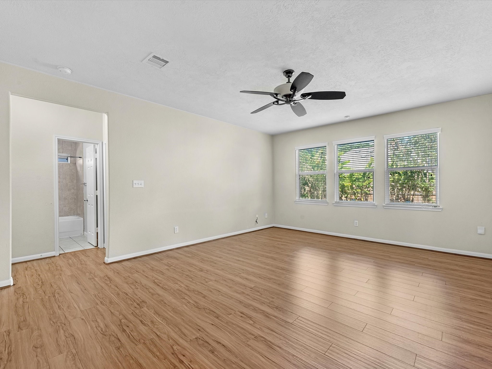 13307 Bomoseen Lake Road Houston, TX 77044 - Photo 9 of 40 an empty room with wooden floor chandelier fan and windows