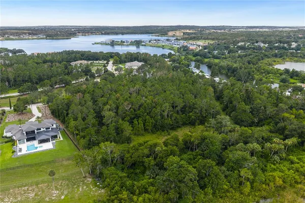 an aerial view of a house with a garden and lake view
