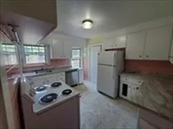 a kitchen with a refrigerator and a stove top oven