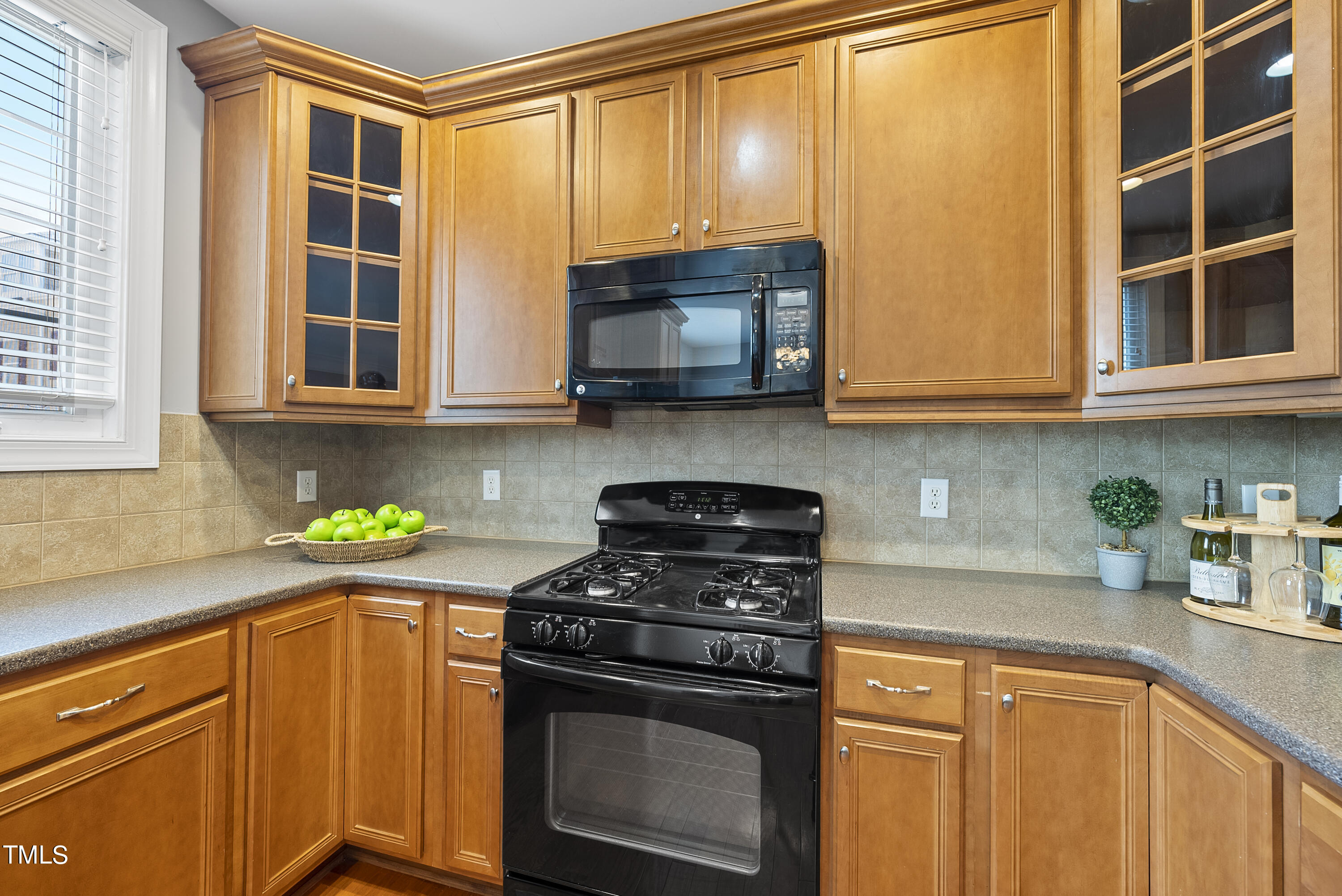 9221 Calabria Drive, Unit 109 Raleigh, NC 27617 - Photo 14 of 34 a kitchen with stainless steel appliances granite countertop wooden cabinets and a stove top oven