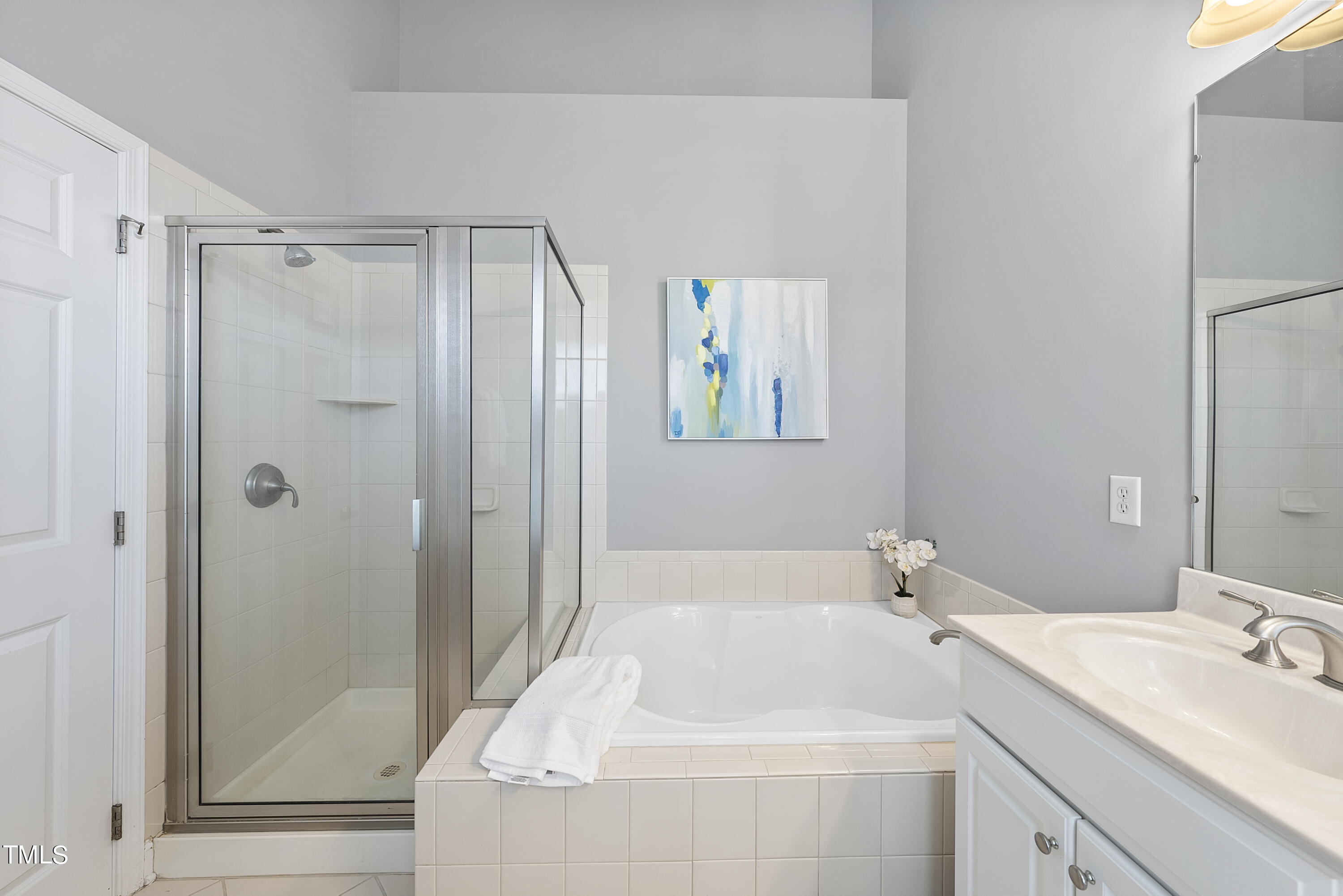 9221 Calabria Drive, Unit 109 Raleigh, NC 27617 - Photo 21 of 34 a bathroom with a tub sink vanity and mirror