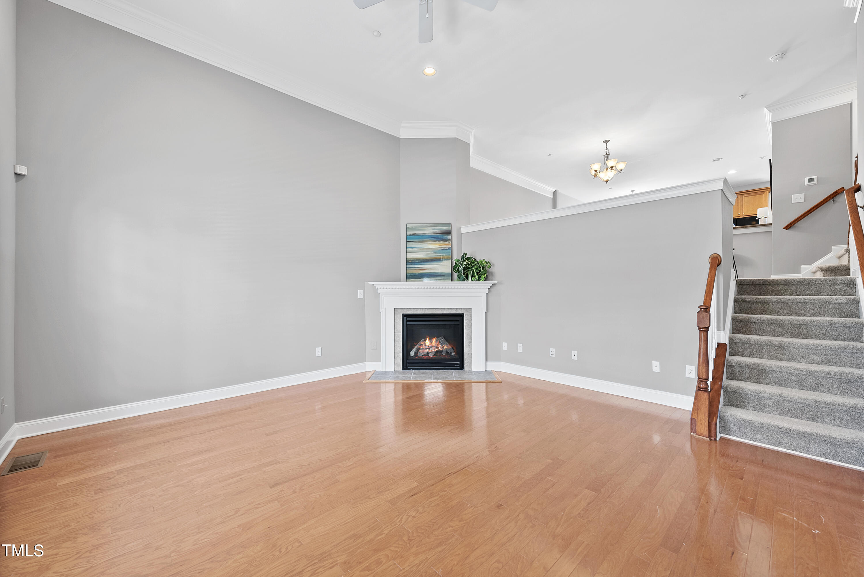 9221 Calabria Drive, Unit 109 Raleigh, NC 27617 - Photo 3 of 34 a view of an empty room with wooden floor fireplace and a window