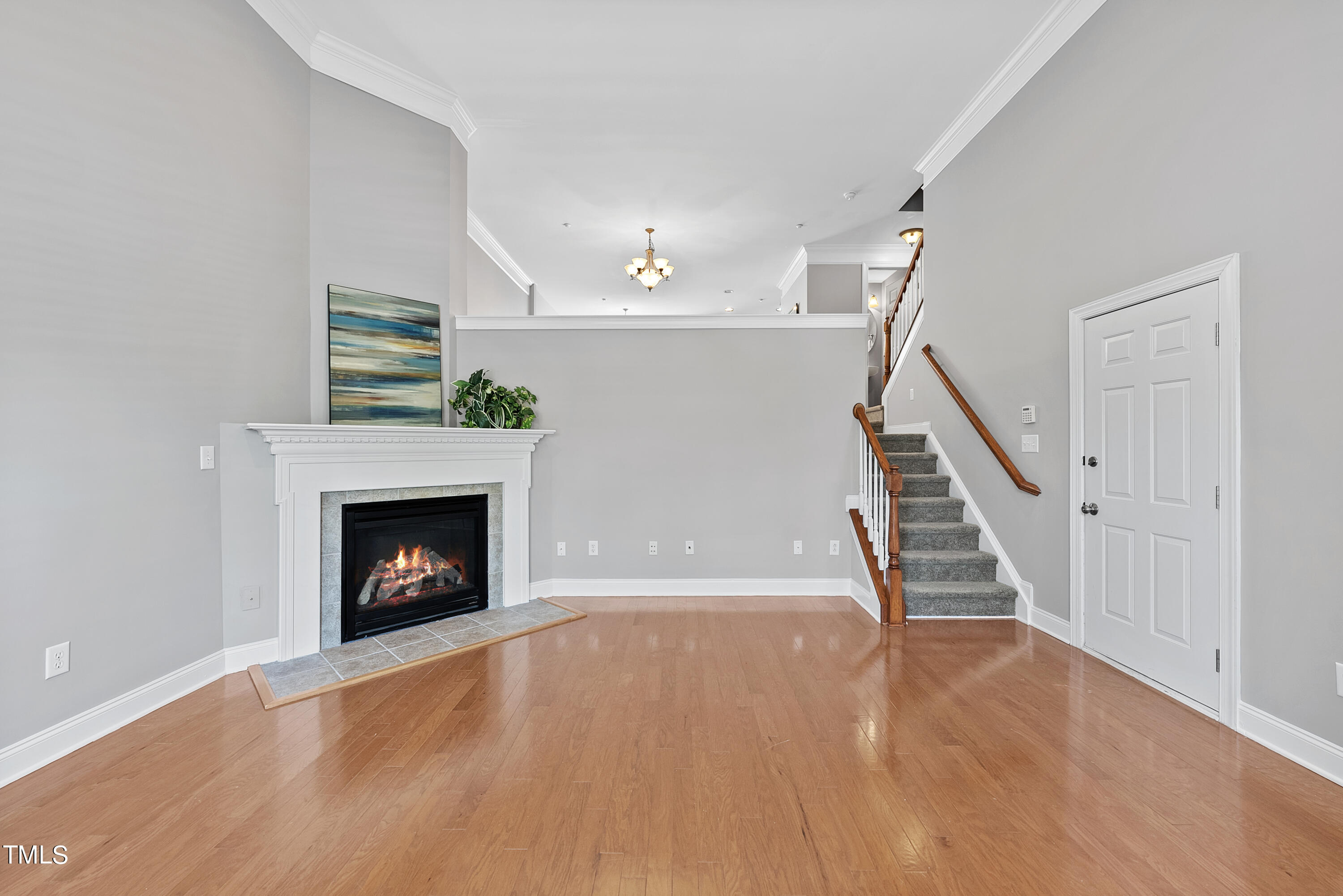 9221 Calabria Drive, Unit 109 Raleigh, NC 27617 - Photo 4 of 34 a view of an empty room with wooden floor fireplace and a window
