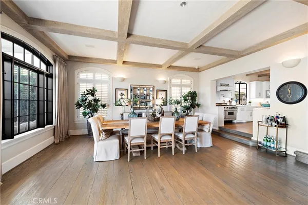 a living room with furniture large window and wooden floor