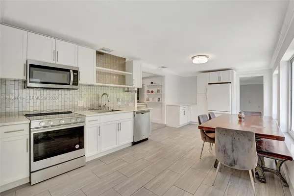 a kitchen with a stove a sink and a microwave